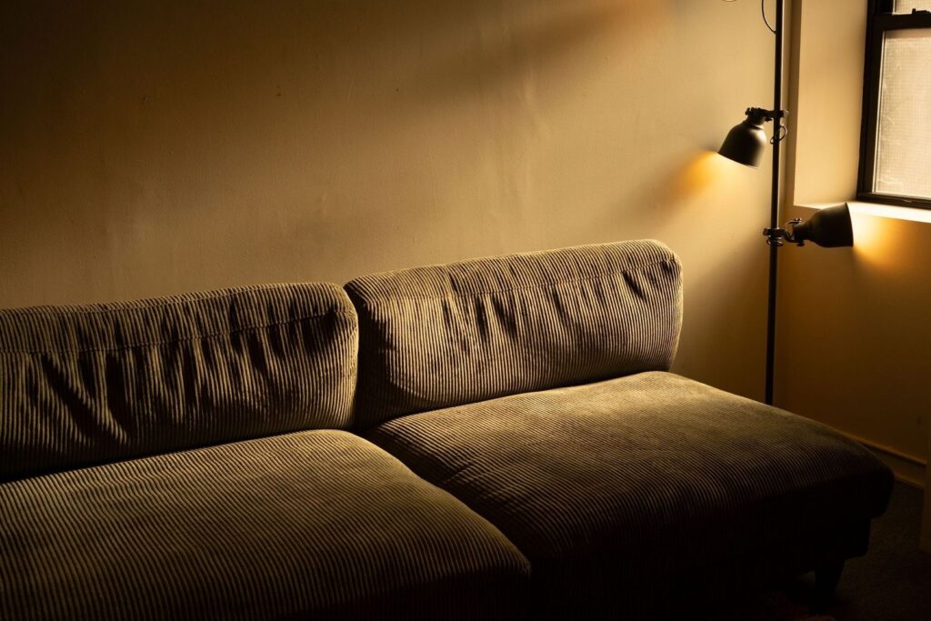 Soffa i varm belysning från två riktbara lampor i vardagsrum